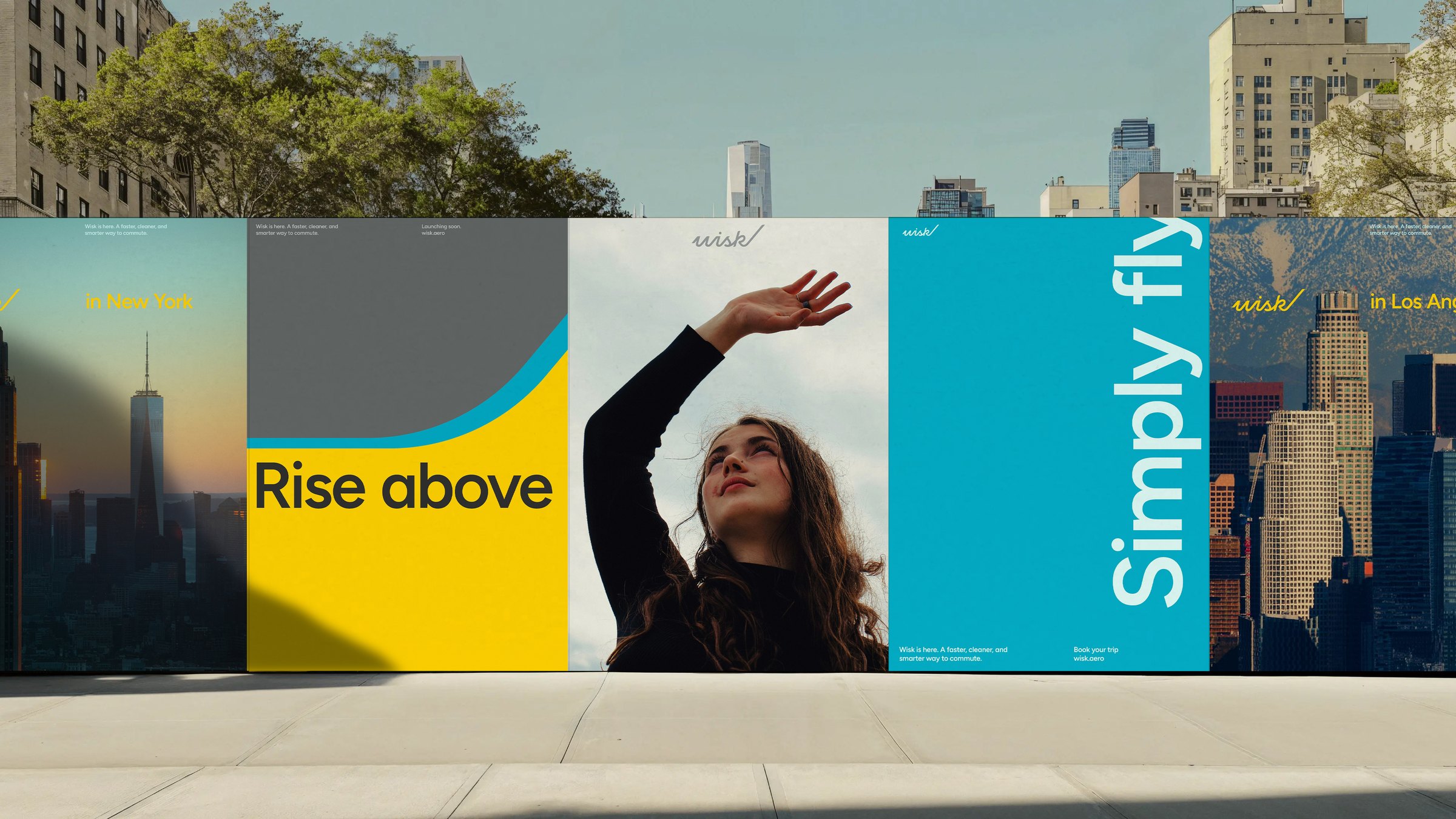 A row of Wisk street posters: New York skyline, Rise above, a woman reaching for the sky, Simply fly, and Los Angeles