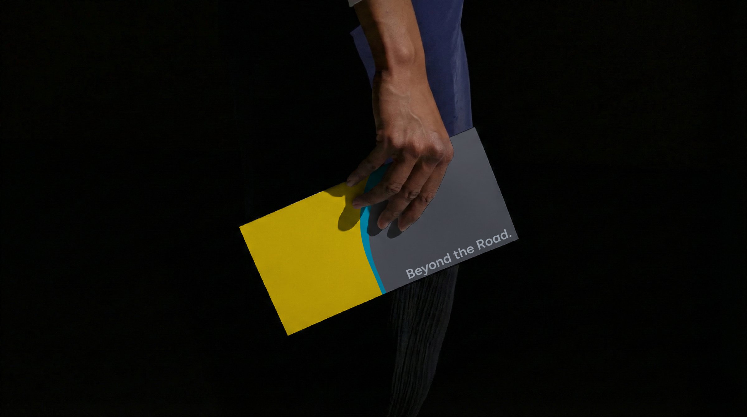 Hand holding a yellow and grey Wisk brochure that reads Beyond the Road