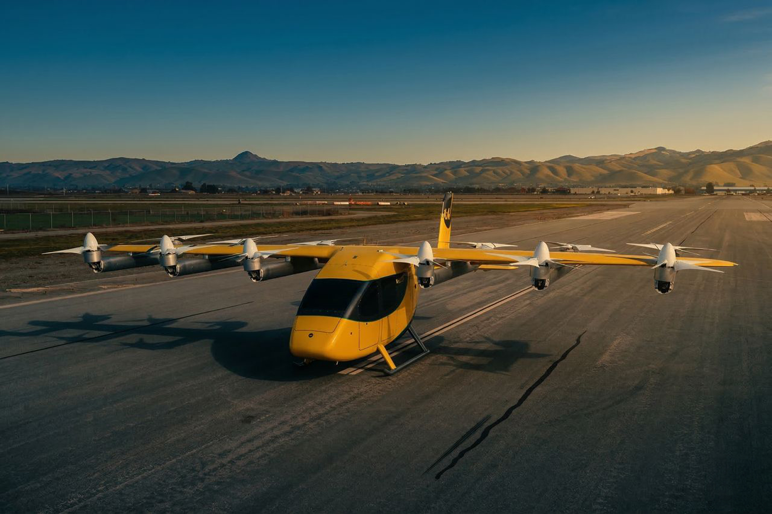 Wisk Generation 6 air taxi on a runway at sunset